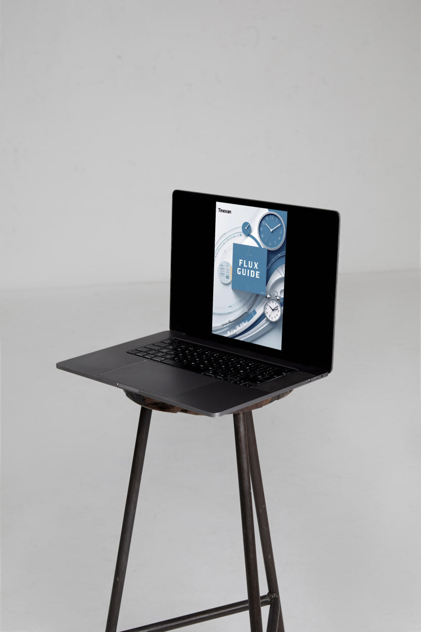 Laptop on a stand with a product display on the screen against a gray background